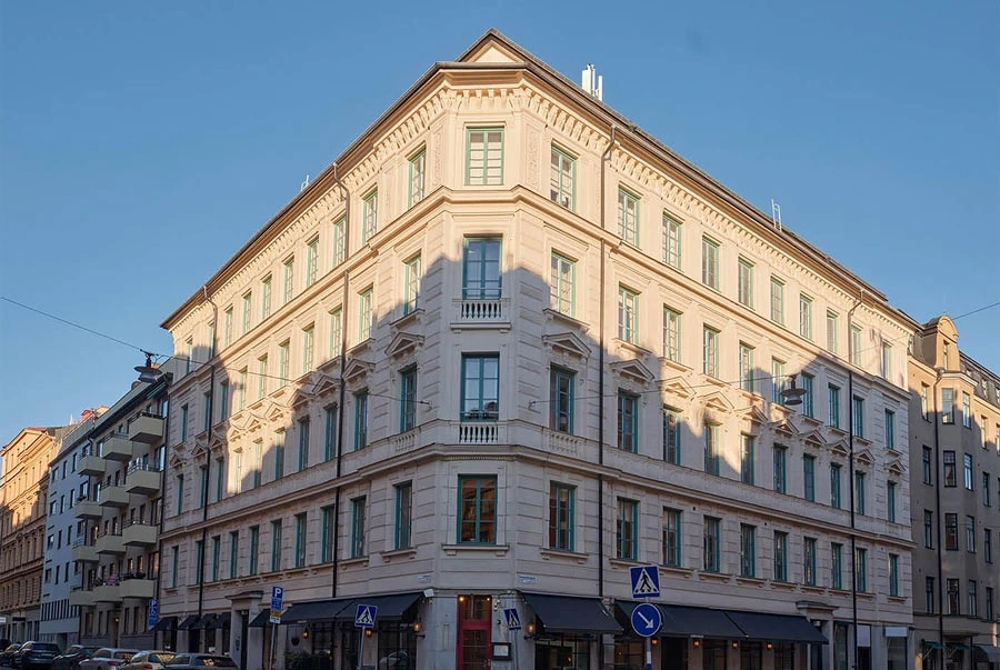 Byggarbetsplats med ställningar och byggmaterial framför tegelbyggnad
